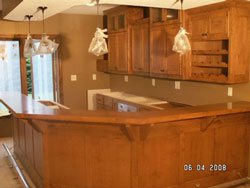 A long bar counter with reddish colored wood