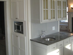 A custom sink in a gray granite counter top with white cabinetry
