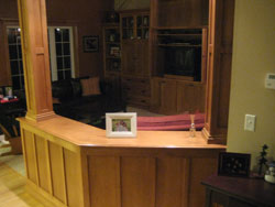 A curved wooden room divider with custom columns