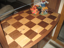 A shelf with a light and dark wooden checkerboard pattern